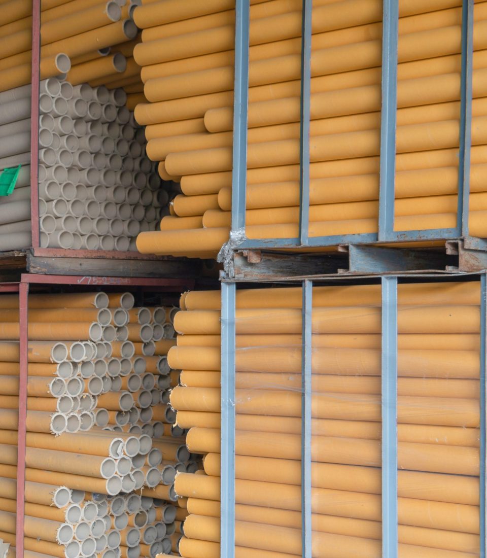 Stack of a bunch of paper tube cores, tissues, in industry manufacturing plant factory. Raw product material of brown paper rolls. Cardboard cylinder cargo pattern in stock workshop storage warehouse.